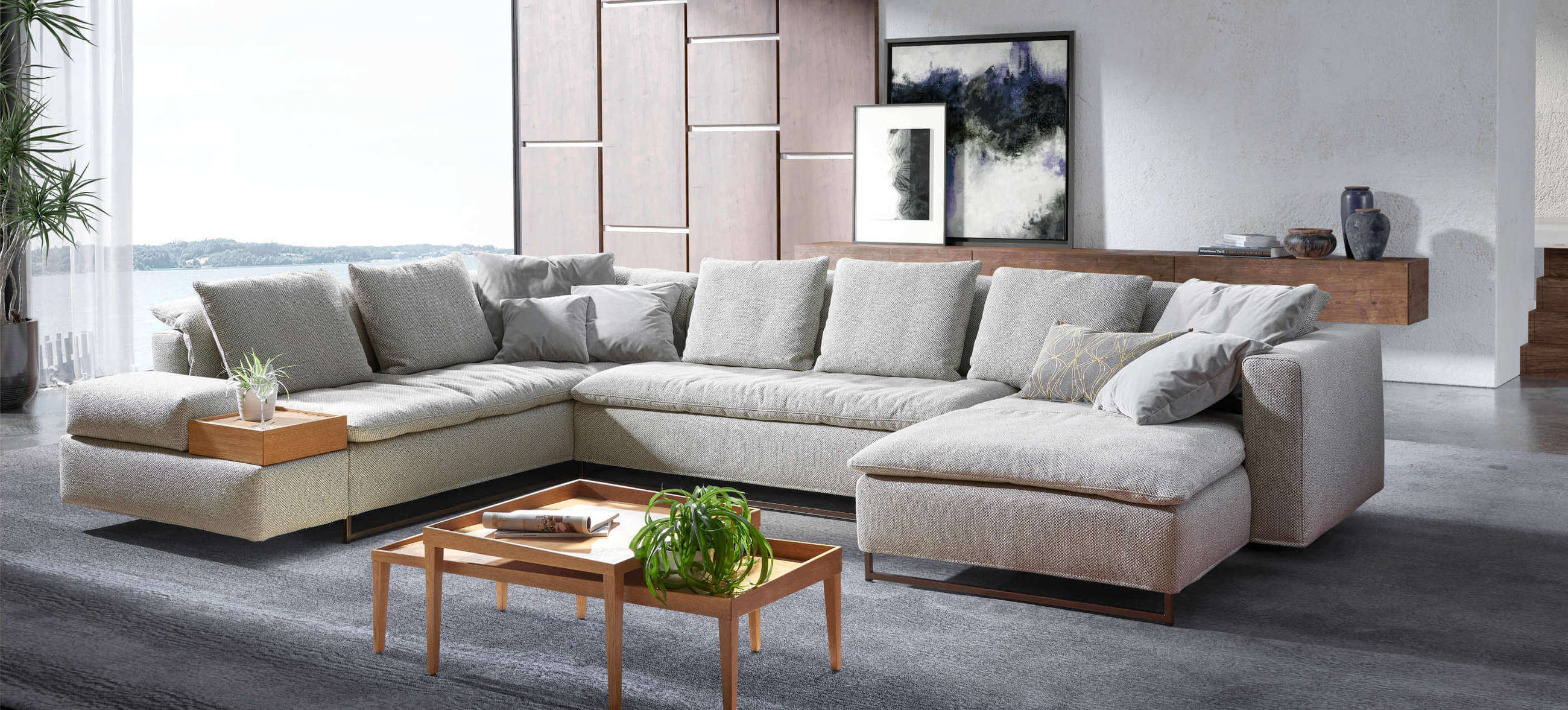 Ecksofa Isla von Signet in einem modernen Wohnzimmer, kombiniert mit Holzdetails und Kissen für stilvollen Komfort